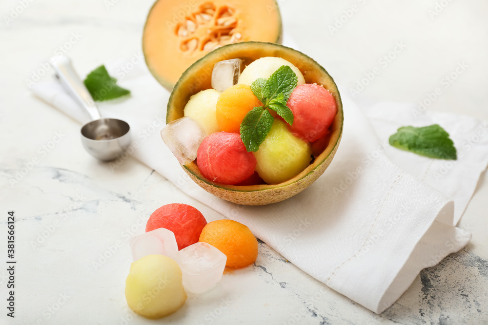 Tasty melon balls with ice on white background