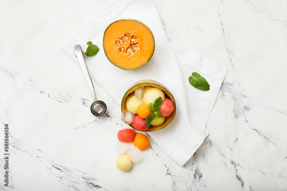 Tasty melon balls with ice on white background