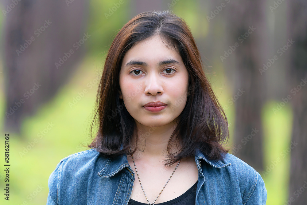 Portrait asian woman standing outsite with blur tree background