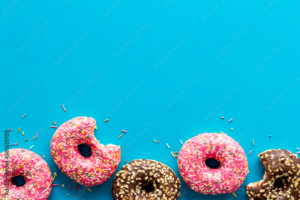 Donuts flat lay pattern on blue background, top view