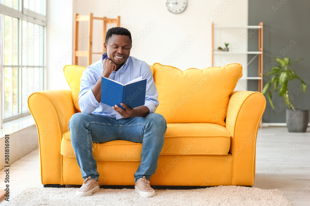 African-American man reading book at home