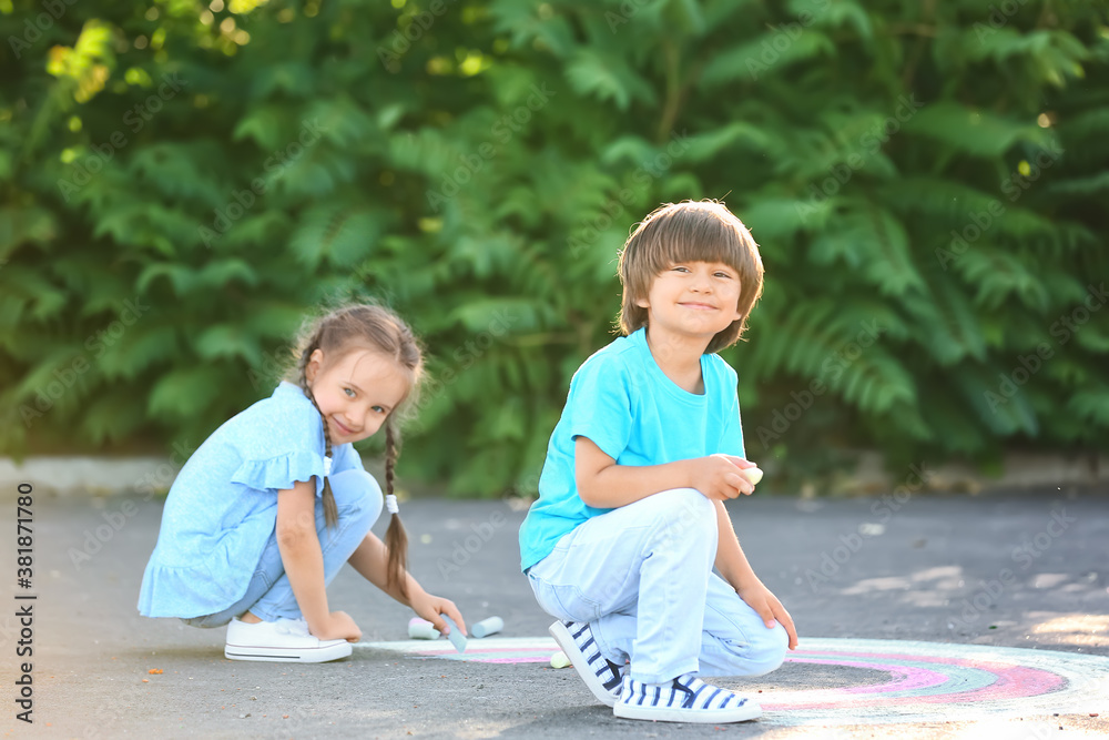 Little children drawing with chalk on asphalt