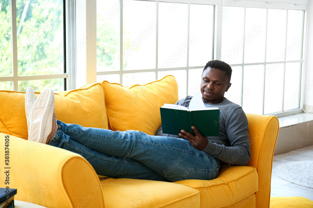 African-American man reading book at home