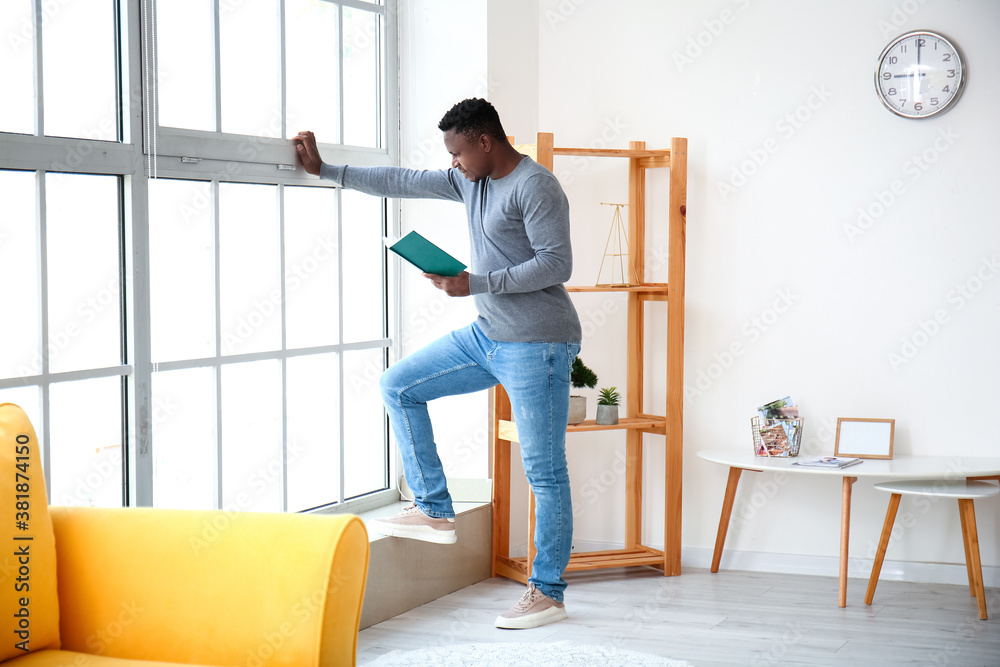 African-American man reading book at home