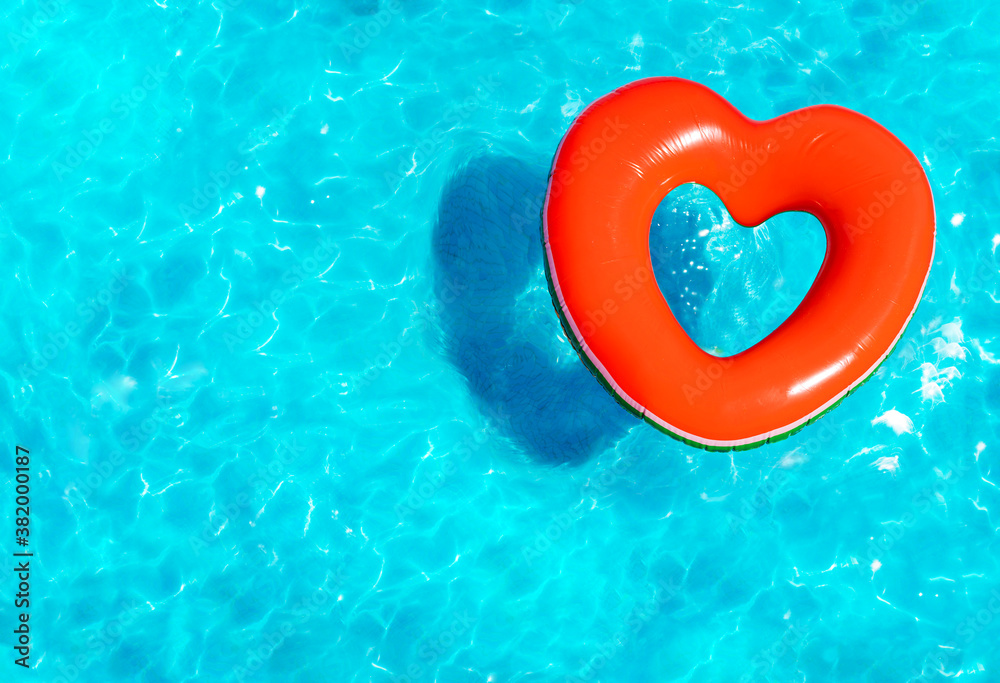 Inflatable red heart buoy swim in the swimming pool view from above