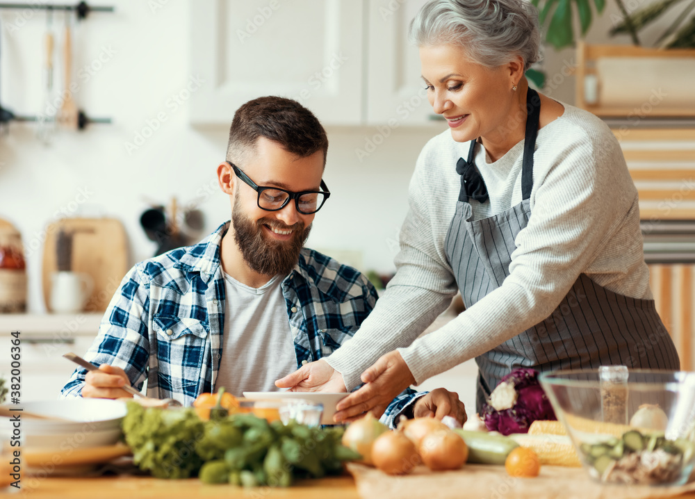 Happy mother serving healthy food to adult son at home.