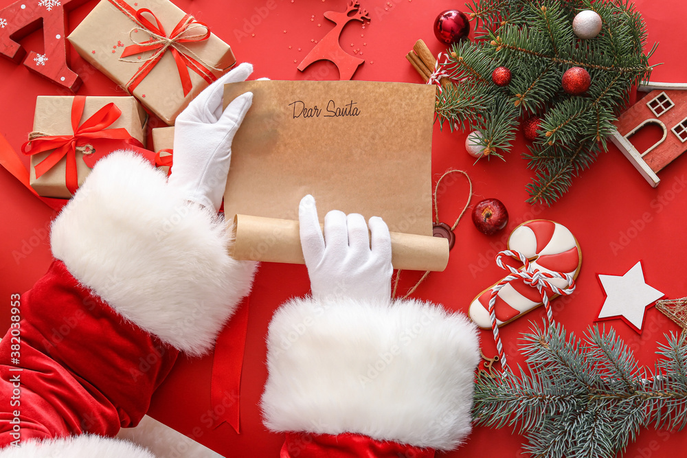 Santa with letter and Christmas decor on color background