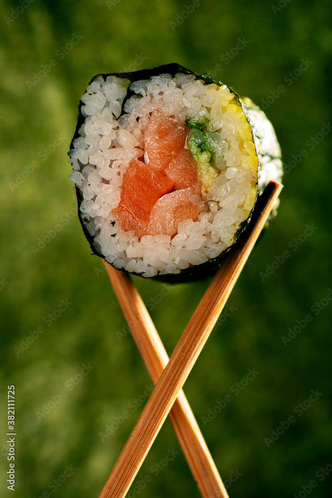 Salmon and Avocado Sushi Roll. Detailed closeup macro food background.