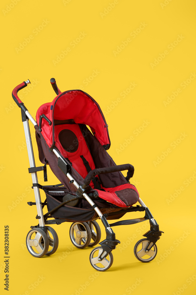 Modern baby stroller on color background