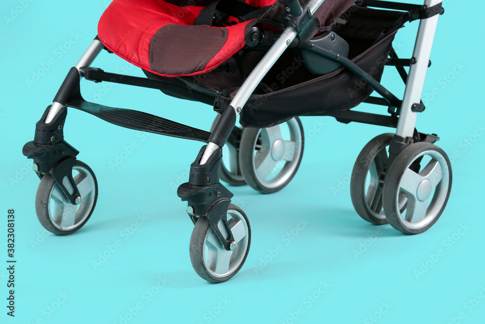 Modern baby stroller on color background