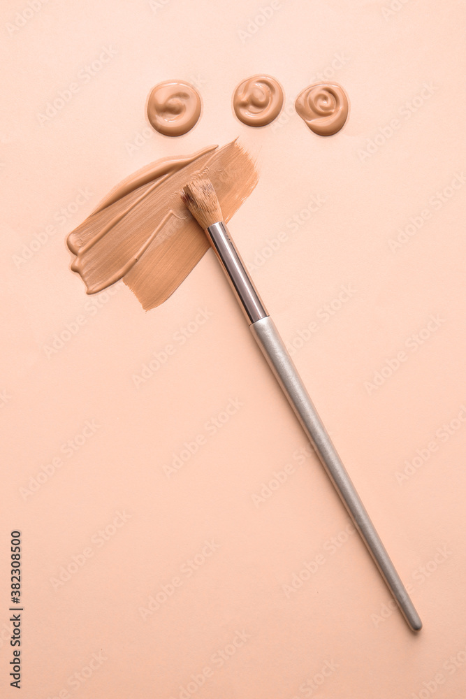 Samples of foundation for makeup and brush on color background