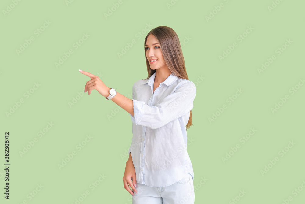 Young woman with wristwatch on color background