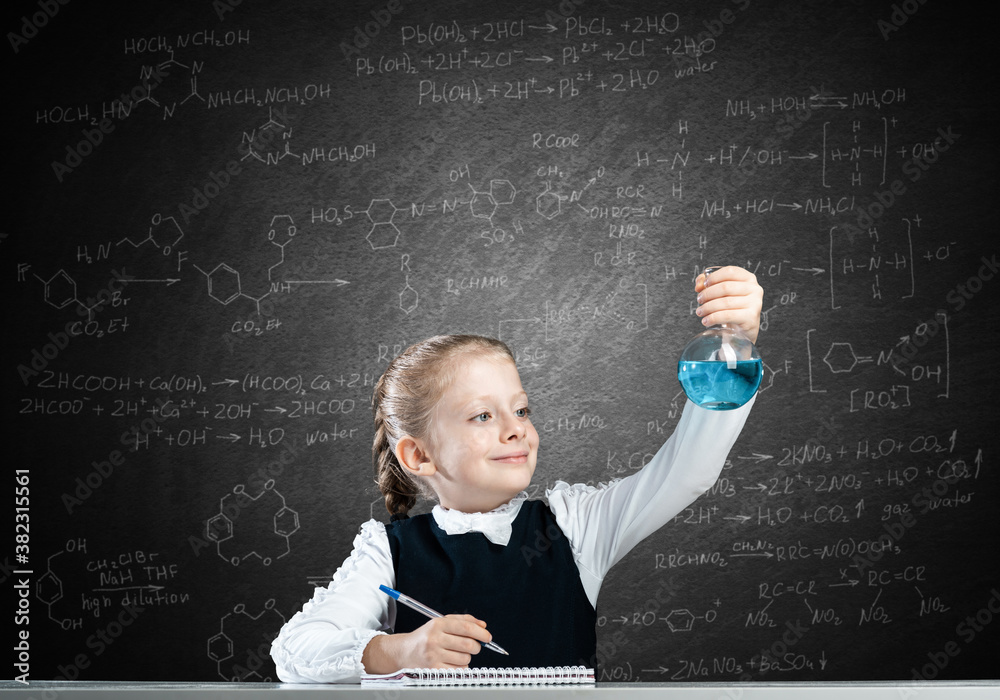 Little girl scientist examining test tube