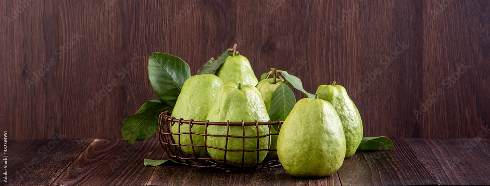 Delicious beautiful Guava set with fresh leaves isolated on wooden table background, close up.