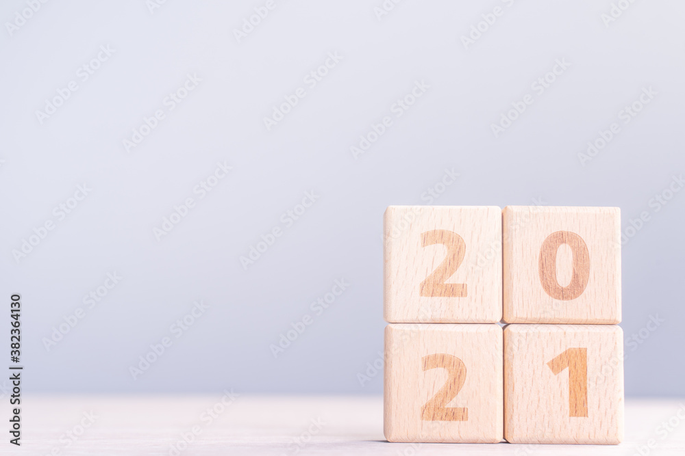 2021 New Year abstract design concept - Number wood block cubes isolated on wooden table and light m