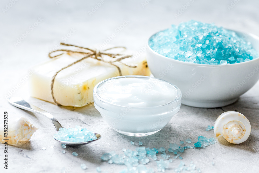 spa composition with blue sea salt and natural soap on stone desk background