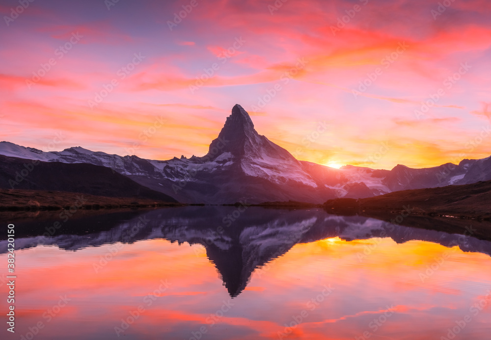 Picturesque landscape with colorful sunrise on Stellisee lake. Snowy Matterhorn Cervino peak with re