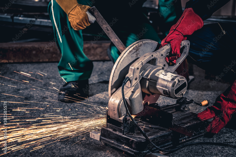 Professional mechanic man is cutting steel metal with rotating carbon blade cutter. Steel industry a