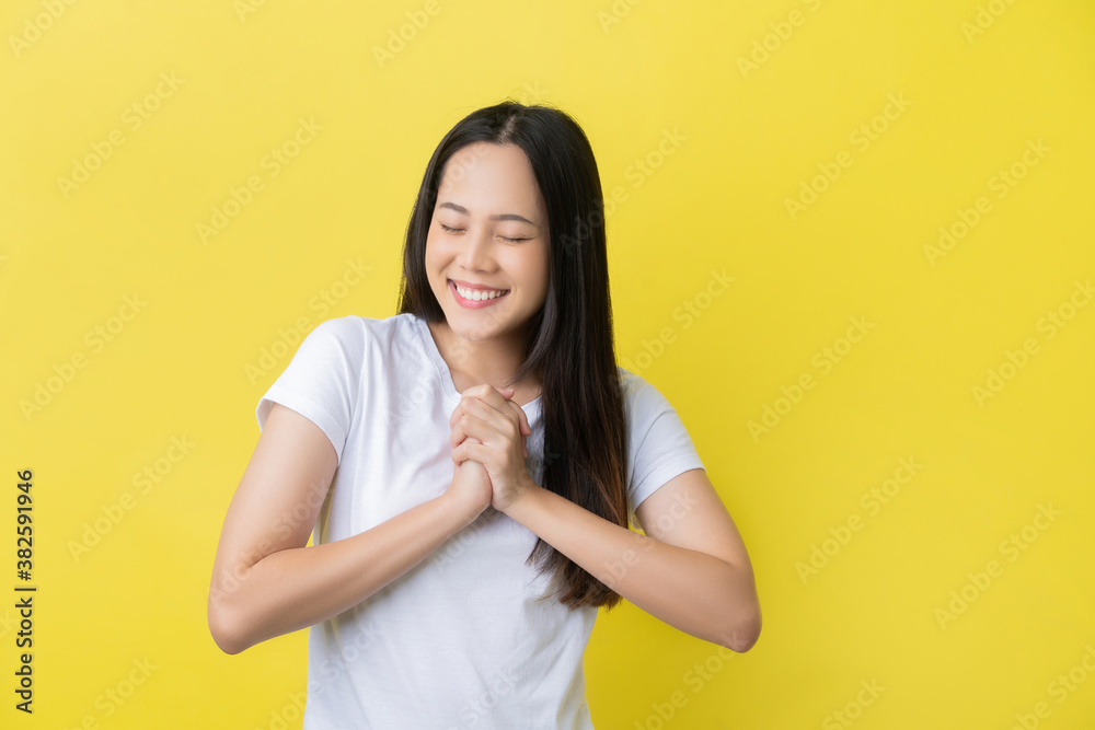 Asian woman she is hoping on a yellow background