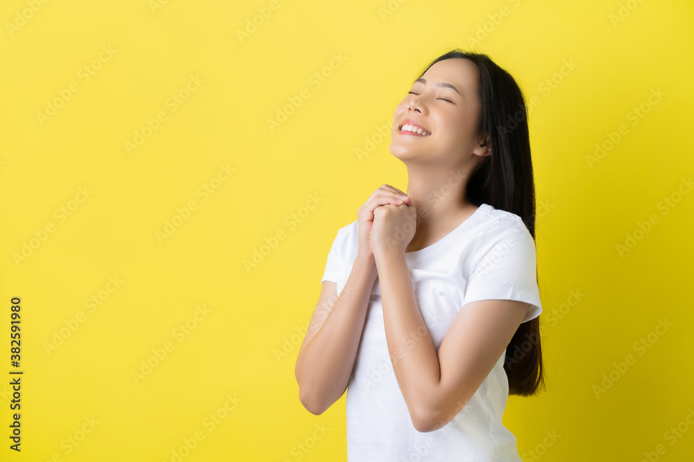 Asian woman she is hoping on a yellow background