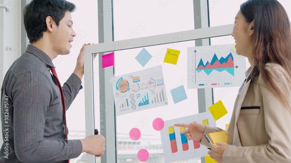 Business people work on project planning board in office and having conversation with coworker frien