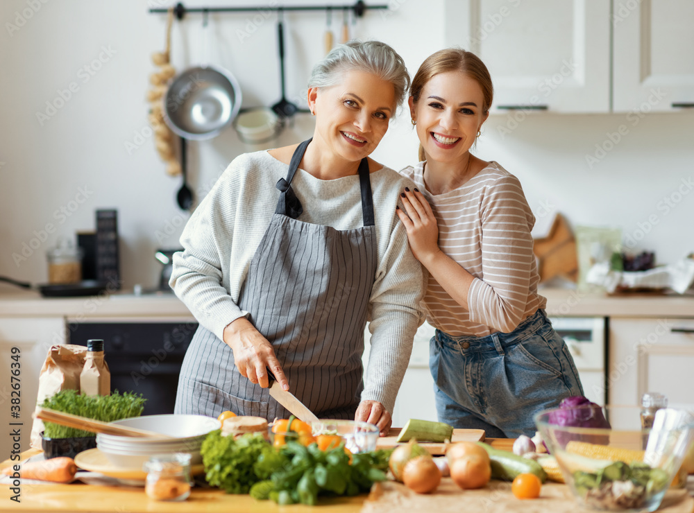 Happy mother and daughter preparing healthy food at home.