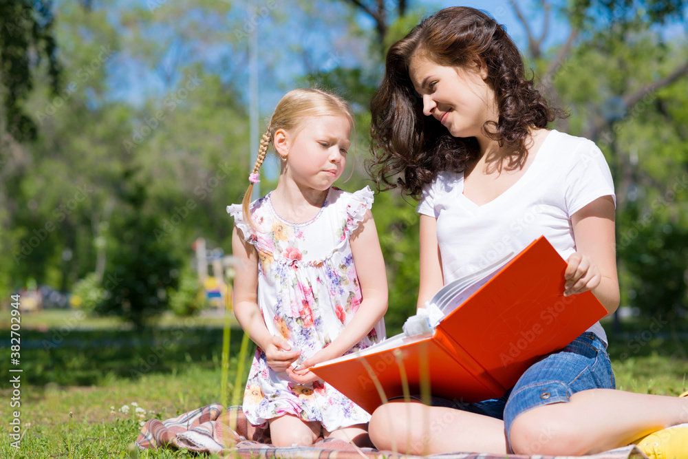 girl and a young woman reading a book together