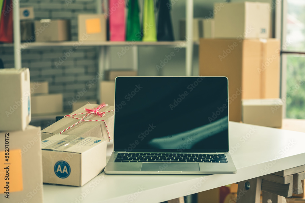 Laptop computer with empty screen on shipping box background. Concept of online retail store, delive