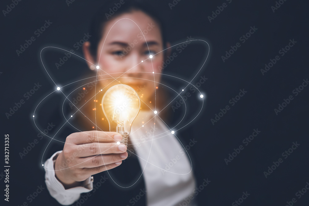 Business Asian woman Holding Illuminated Light Bulb with innovative and creativity are keys to succe