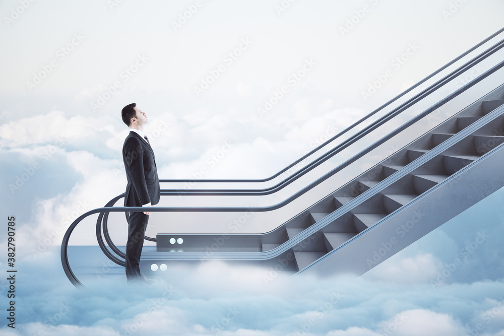 Businessman in suit going up by escalator among clouds.