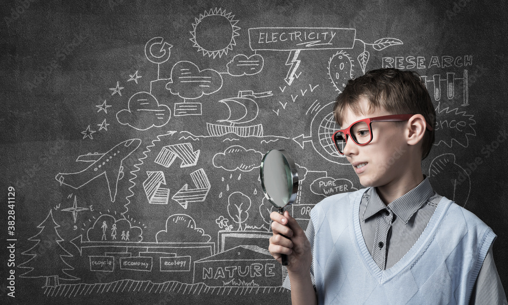 Curious school boy with magnifier