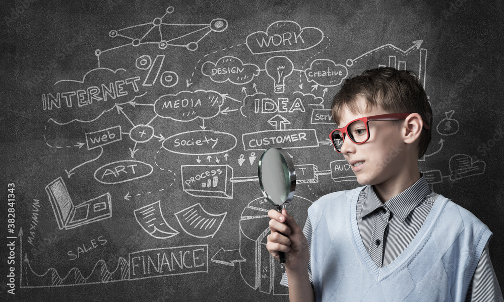 Curious school boy with magnifier