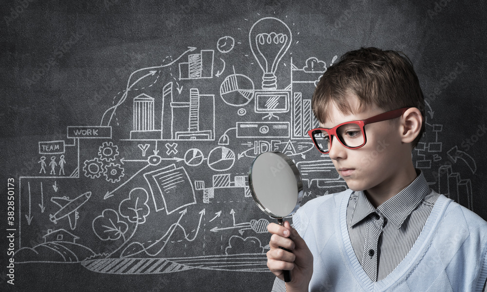 Curious school boy with magnifier