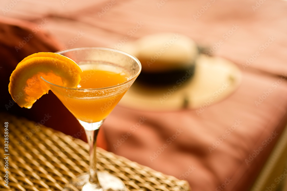 orange cocktail glasses on rattan bench at wooden cruise deck summer vacation moment relax and peace