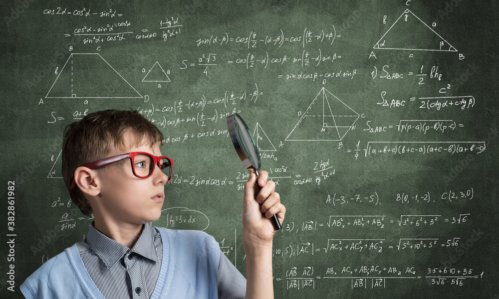 Curious school boy with magnifier