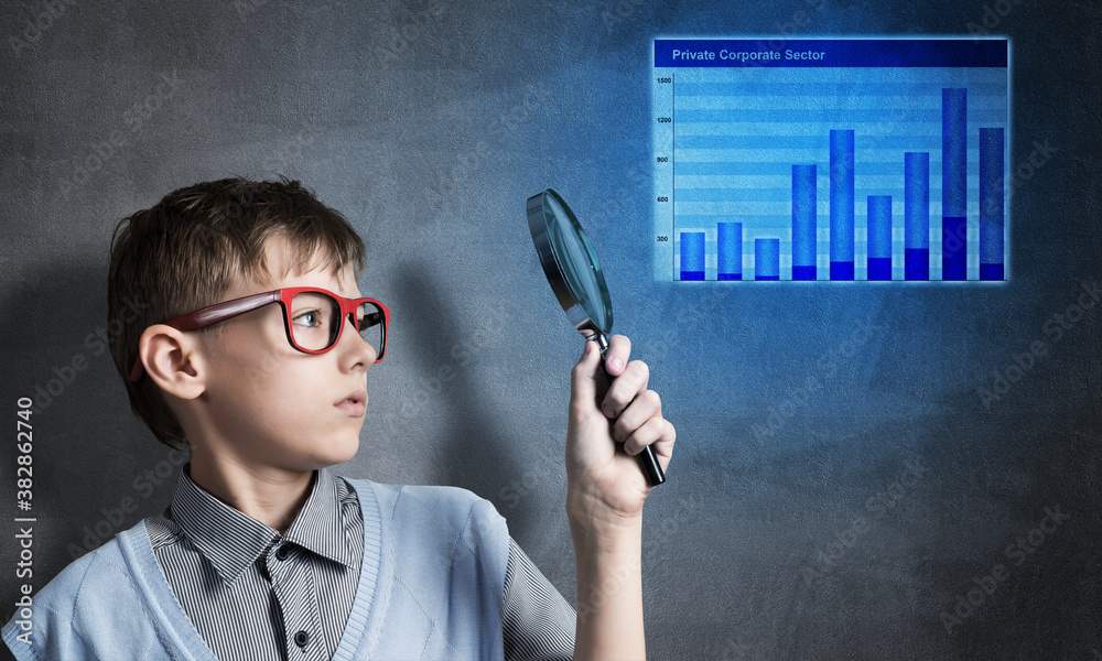 Curious school boy with magnifier