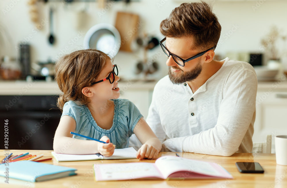 Happy girl with father doing homework.