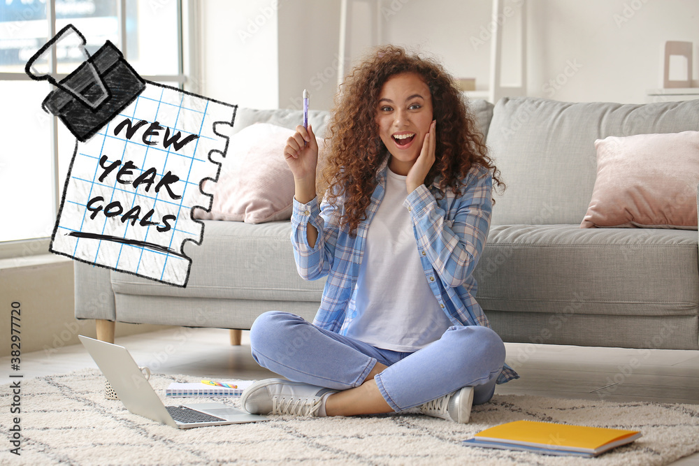 Happy woman with laptop making to do list at home