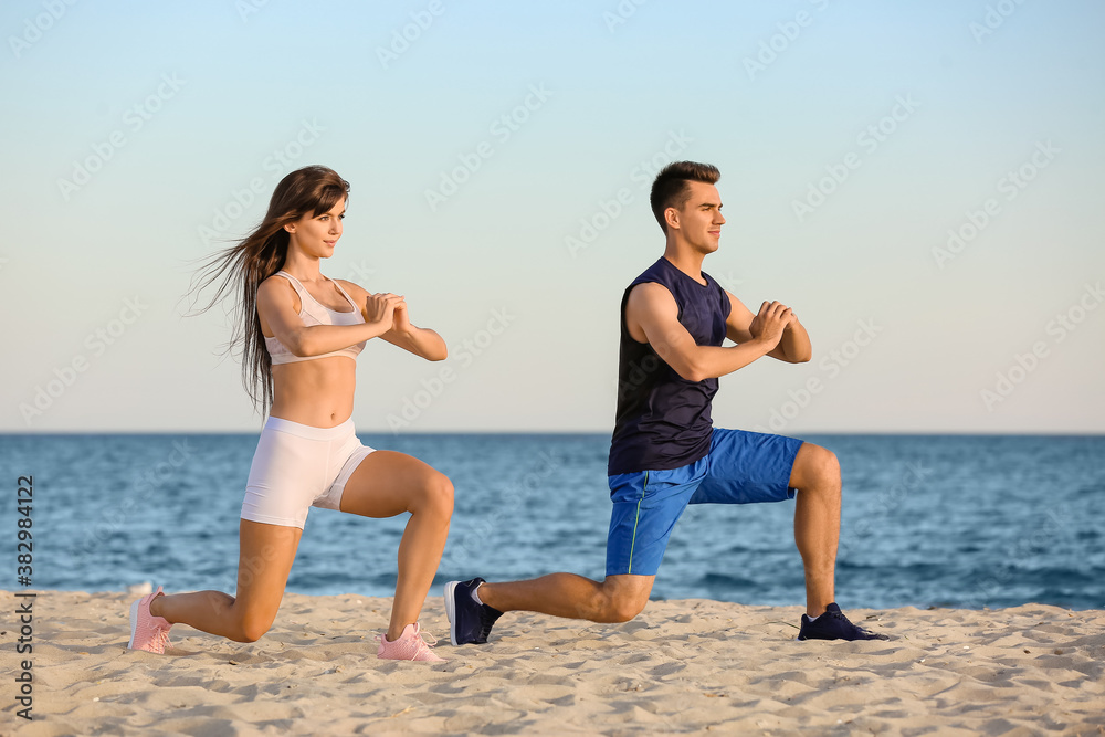 Sporty young couple training on sea beach