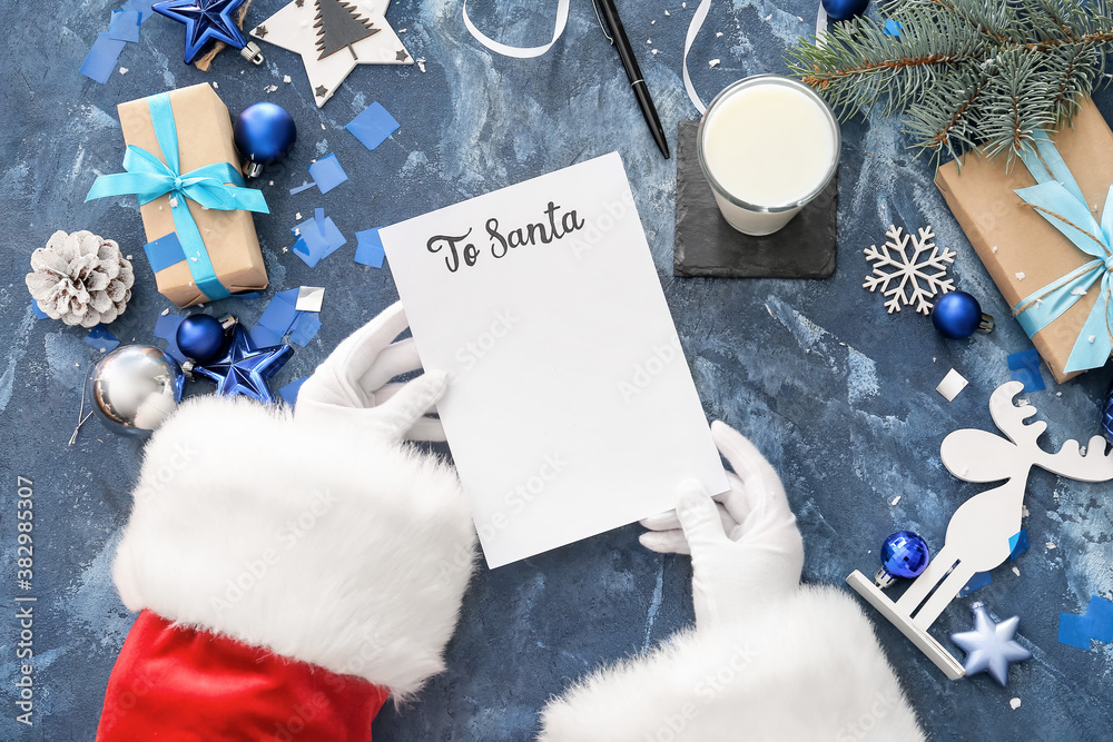 Santa Claus reading letter at table