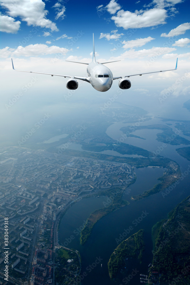 White airplane flying above clouds in the sky