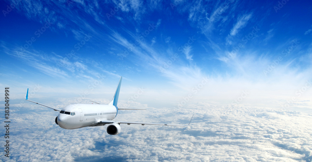 White airplane flying above clouds in the sky