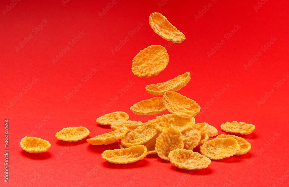 Falling corn flakes isolated on red color background, full depth of field