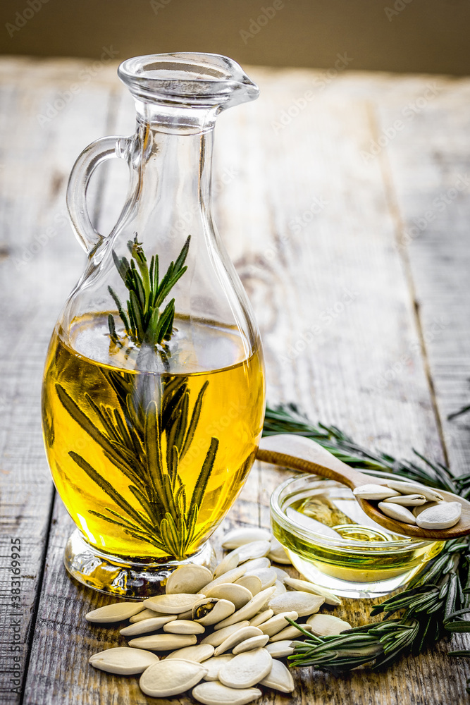 jar with oil with pepitas on wooden table background