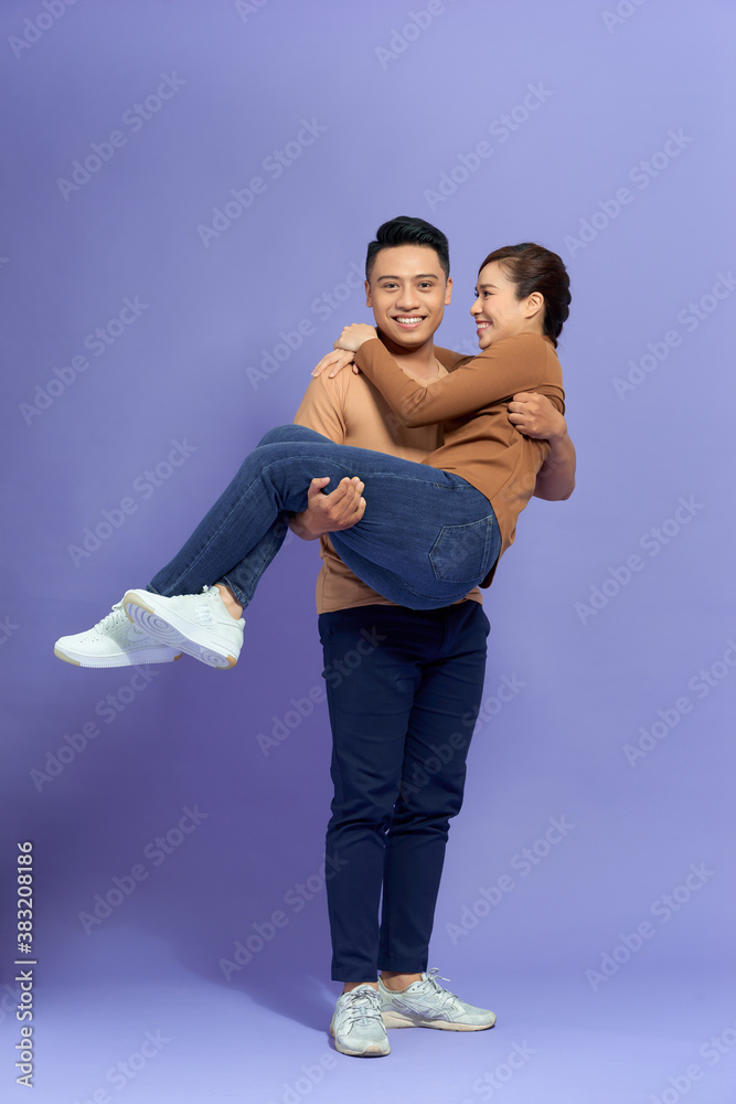 Young man holding girlfriend in his arms