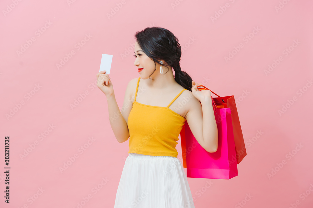 Portrait of pretty charming glad woman carrying many colorful bags in hands gesturing credit plastic