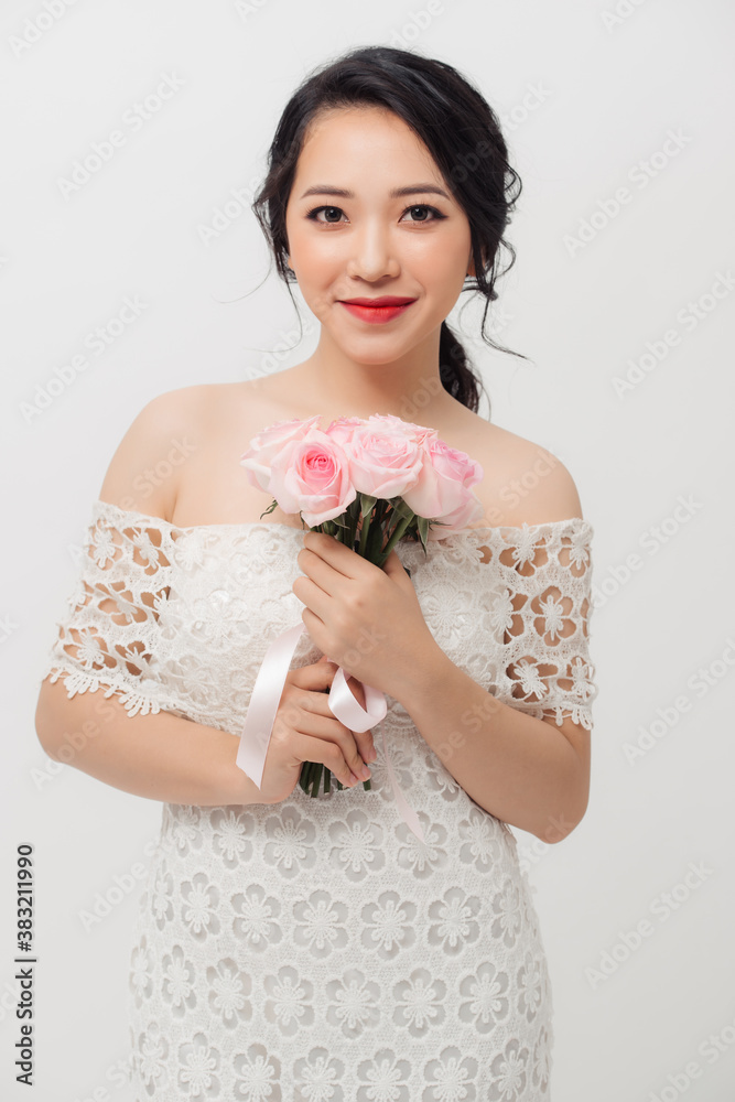 Happy Asian young attractive woman holding flower bouquet and wearing white background.