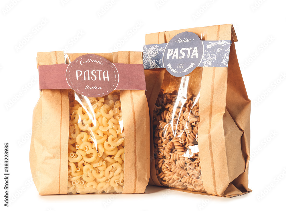 Bags with uncooked Italian pasta on white background