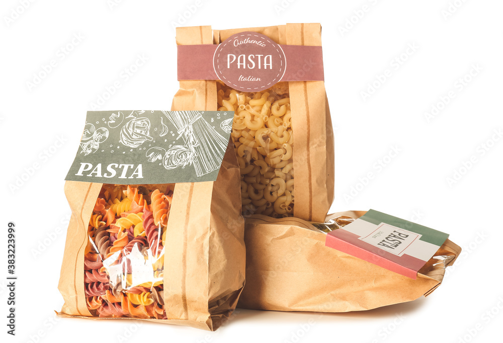 Bags with uncooked Italian pasta on white background