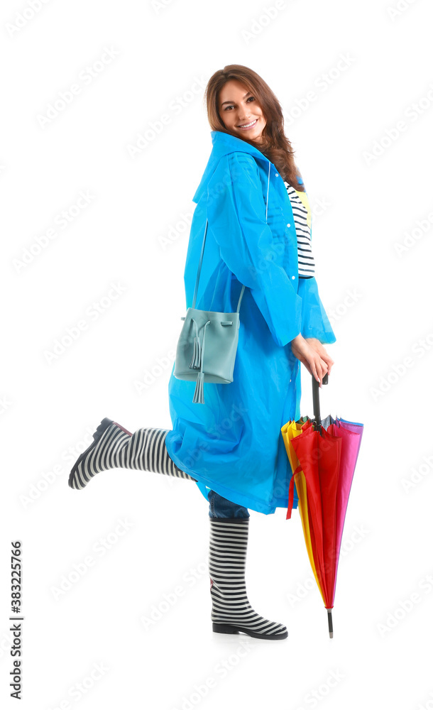 Beautiful young woman in raincoat and with umbrella on white background